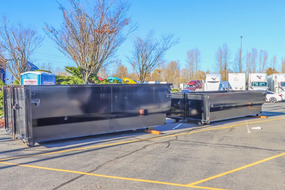 Professional dumpster rental service with roll-off container on residential driveway in Doraville